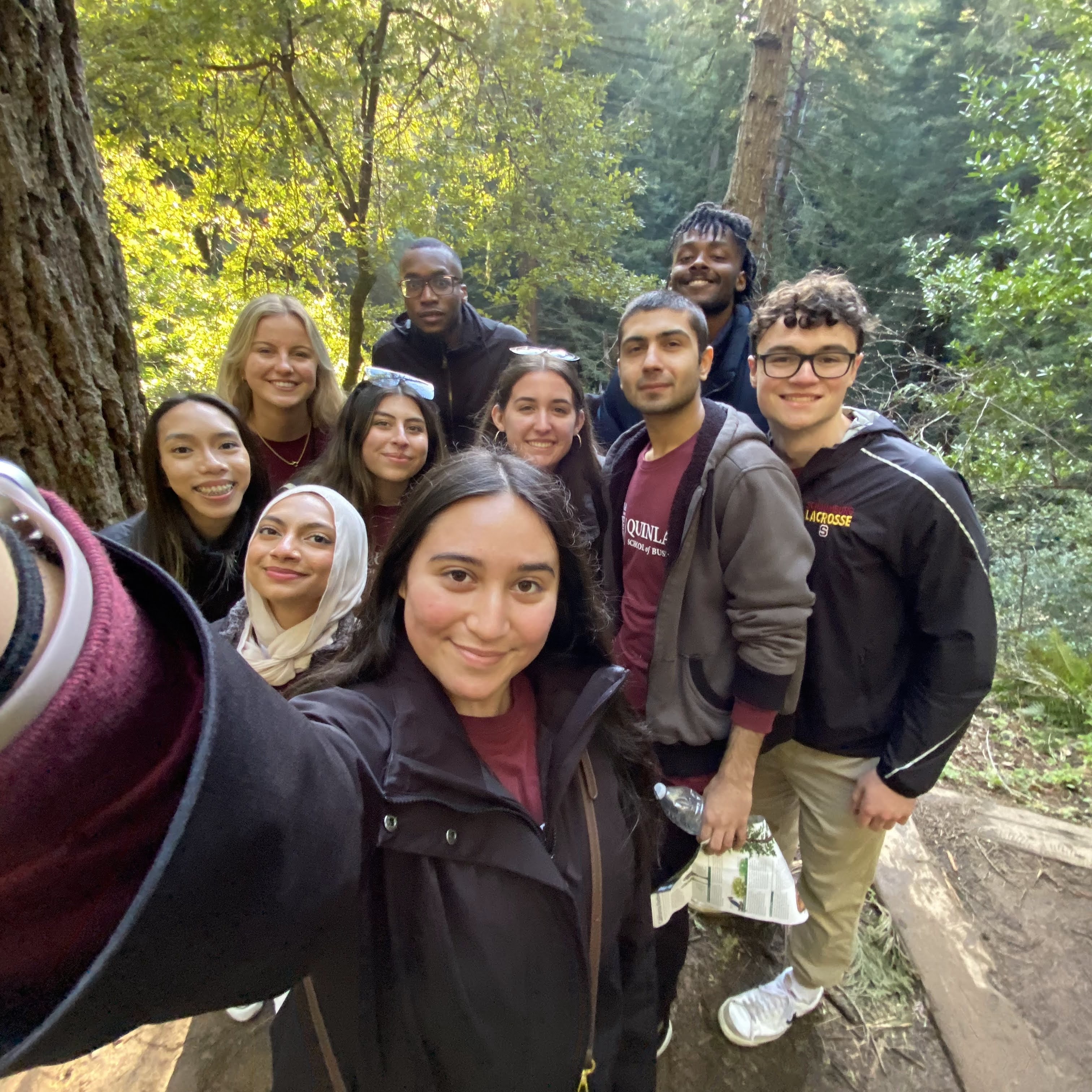 A group of student stake a selfie among trees at Muir Woods National Park in San Francisco, California.